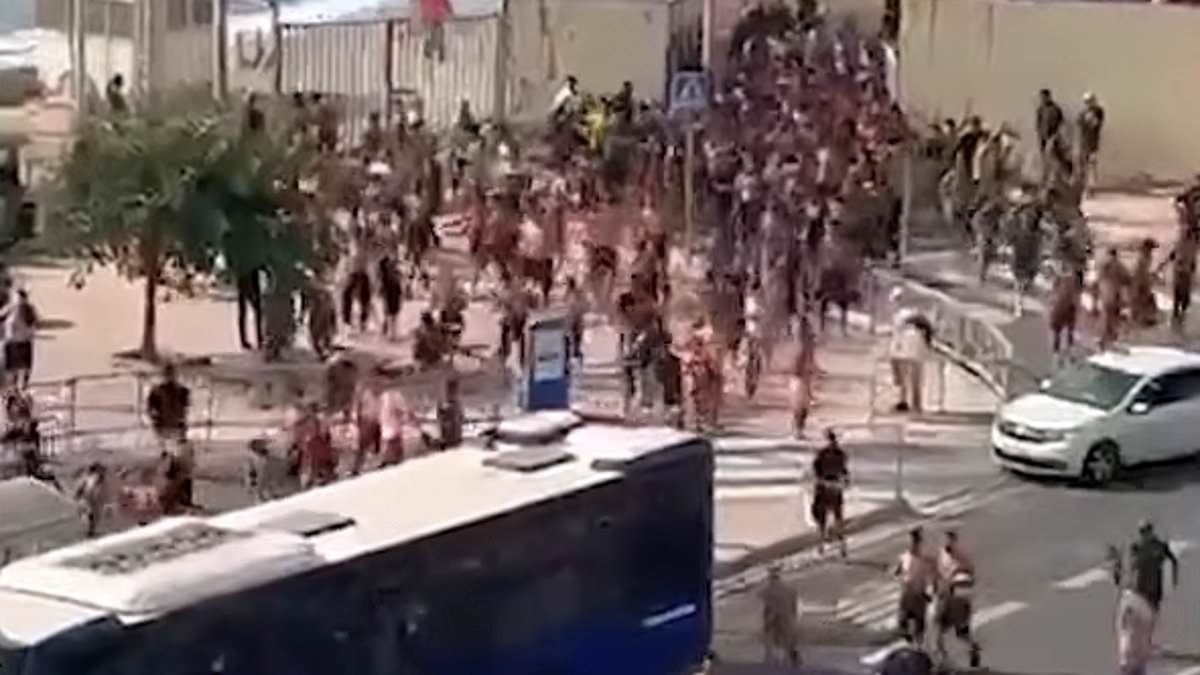 Migrants storm EU border: Moment hundreds charge up beaches and force their way into Spanish enclave as it declares 'total emergency'